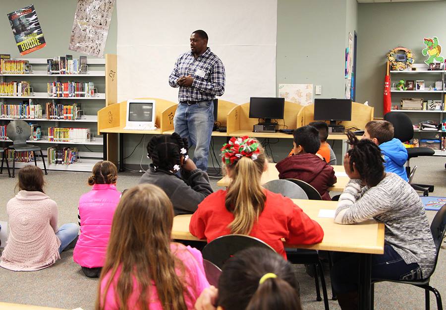 Man speaking to children in a library