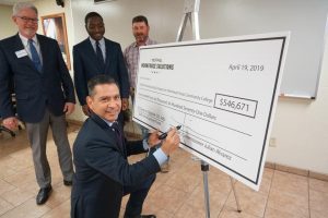 Man signing large check