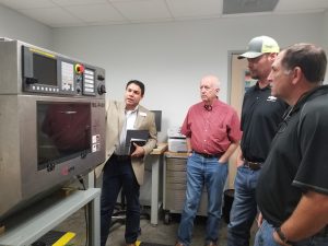 Man demonstrating equipment to three other men